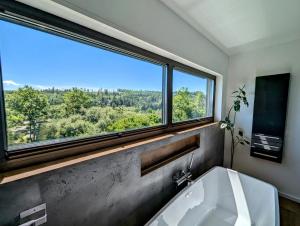 a bathroom with a bath tub and a large window at Bergkultur Sauerland in Medebach