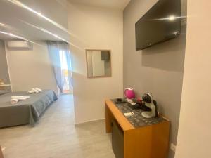 a room with a bed and a table and a television at Glicine in Parghelia