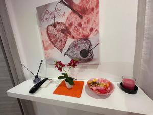 a table with a remote control and a bowl of fruit at Glicine in Parghelia