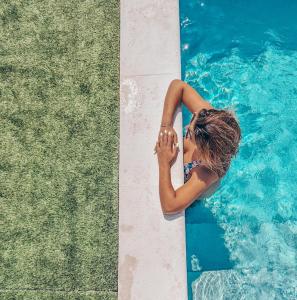 a woman standing next to a swimming pool at Casa da Espiga - Alentejo in Trigaches