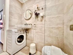 a bathroom with a washing machine and a sink at Charming flat off the sea front in Il-Gżira +46 photos
