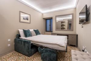 バレッタにあるStylish Seaview Valletta Houseのベッドルーム(ベッド1台、ソファ、鏡付)