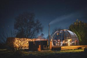 a domed greenhouse with people in it at night at Sphair aux merveilles - Dôme romantique avec vue panoramique sur la nature in Faimes +7 photos