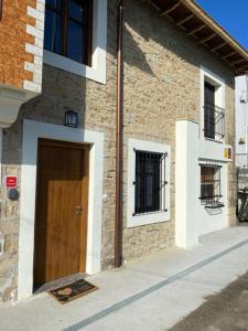 a building with a wooden door on the side of it at Casa los Patos en Santillana Del Mar in Santillana del Mar