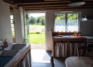 a kitchen with a sink and a counter with a window at La Contrebasse in Drucourt