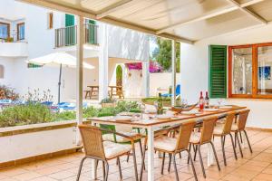 a wooden table and chairs on a patio at Villa Rigo by Villa Plus in Cala D'or