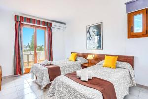 a room with three beds and a window at Villa Rigo by Villa Plus in Cala D'or +29 photos