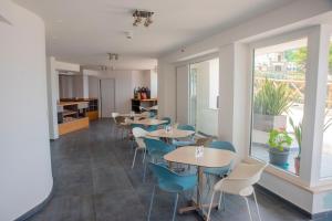 un ristorante con tavoli e sedie e una grande finestra di Hotel Ficocella a Palinuro