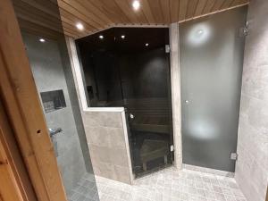a shower with a glass door in a bathroom at Ruka Saaruakuja 3 as 1-4 in Ruka