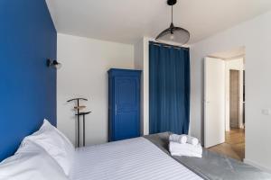 a bedroom with blue walls and a bed with two towels at Instant Détente - Appt à 50 m de la plage in Pléneuf-Val-André