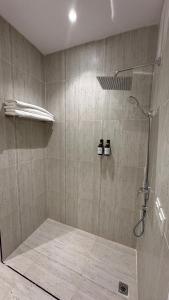 a bathroom with a shower with two bottles in it at شقة فاخرة من 3 غرف بكمباوند الماجدية in Riyadh +14 photos