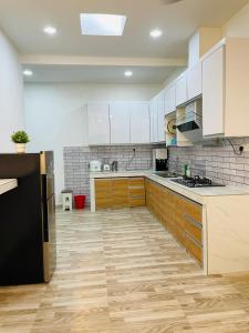 a kitchen with white cabinets and a black refrigerator at Nazirin Homestay No 27 Tmn Desa Manjung Lumut in Lumut