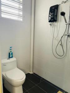a bathroom with a toilet and a shower at Nazirin Homestay No 27 Tmn Desa Manjung Lumut in Lumut