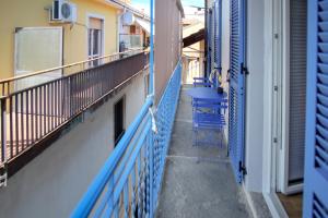 a balcony of a building with blue railings and a chair at Torre di Londra in Stresa
