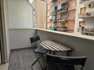 a table and a chair on a balcony with a window at B&B Nazionale in Naples