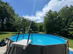 a chair sitting next to a swimming pool at Idila pod Rtnjem - Najam cele vikendice sa bazenom in Ilino