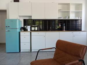a kitchen with a blue refrigerator and a chair at TopFlat in Dortmund
