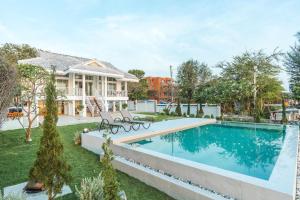 a house with a swimming pool in a yard at 26Villa Huahin in Khao Tao