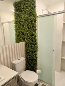 a bathroom with a green wall next to a toilet at Lofts | Consolação | 3 min Metrô in Sao Paulo +79 photos