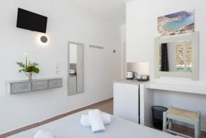 a white room with a bed and a mirror at Simeon Rooms & Apartments in Kamarai