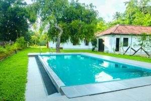 a swimming pool in the yard of a house at Chandana1941 in Ambalangoda