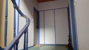 einen Flur mit einer weißen Tür und einer Treppe in der Unterkunft Studio vue mer 1r étage avec balcon in Les Sables-dʼOlonne