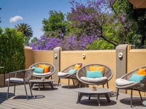 a group of chairs with colorful pillows on a deck at Casa Mal&iacute; by Dominion Boutique Hotel in Mexico City