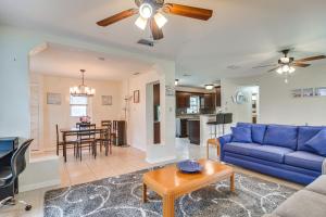 a living room with a blue couch and a table at Charming Seminole Home with Patio 6 Mi to Beaches! in Seminole