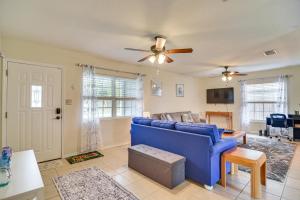 a living room with a blue couch and a ceiling fan at Charming Seminole Home with Patio 6 Mi to Beaches! in Seminole