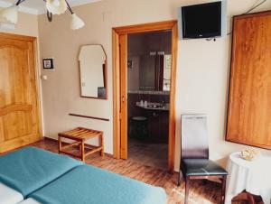 a bedroom with a bed and a table and a chair at Hotel Vitorio in Cudillero
