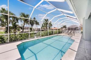 an indoor swimming pool with a clear roof at Pet-friendly waterfront home near beach with pool in Marco Island