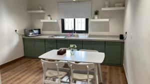 a kitchen with a white table and chairs in it at Unique Home in Yanbu