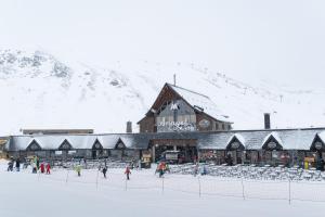 a group of people walking in the snow in front of a building at Apartamento Vico in Escarrilla