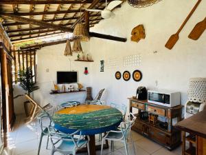 Zimmer mit einem Tisch, Stühlen und einer Mikrowelle in der Unterkunft Casa Branca BG in Barra Grande
