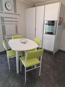 a kitchen with a white table and green chairs at Vitus-Perle in Saint-Vith