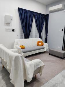 two beds in a room with blue curtains at Melaka privatepool bungalow BBQWIFI krubong in Malacca +23 photos
