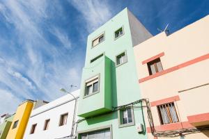 a green and white building with a sky in the background at Apartamento Faycan in Vecindario