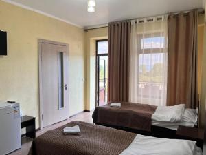 a hotel room with two beds and a window at Aknur Deluxe hotel in Cholpon-Ata +39 photos