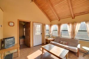 a living room with a couch and a tv at Peaceful Reliance Cabin with Deck on Hiwassee River! in Austral
