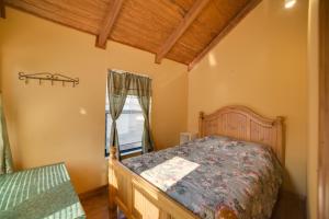 a bedroom with a bed and a window at Peaceful Reliance Cabin with Deck on Hiwassee River! in Austral