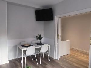 a dining room with a table and chairs and a television at El Mirador De San Juan in Zamora