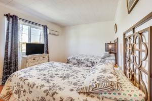 a bedroom with two beds and a tv and a window at Twentynine Palms Harmonic House with Mtn Views! in Twentynine Palms