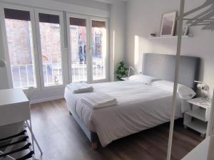 a bedroom with a bed and a desk and windows at El Mirador De San Juan in Zamora