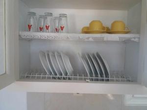 a kitchen shelf with plates and glasses on it at Paradise Serenity in Thólos