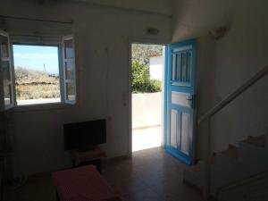 a room with a blue door and a staircase at Paradise Serenity in Thólos