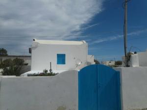 a white building with a blue door in front of it at Paradise Serenity in Thólos