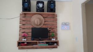 a room with a wooden wall with a tv and speakers at Casa quarto dormitório estudantil a 100m da UESC em salobrinho para uescquianos in Ilhéus