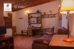 uma sala de estar com um sofá e uma secretária em Alojamientos El Tejado em Buenavista del Norte