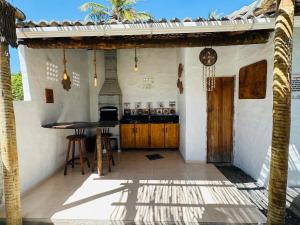 eine Außenterrasse mit einem Tisch und einer Küche in der Unterkunft Casa Branca BG in Barra Grande