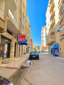 een auto geparkeerd aan de kant van een straat bij Appartement près de la plage in Martil +3 foto's